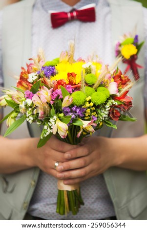 Young man with bouquet of flowers in his hands. Flowers, Spring, Summer, Romance, Wedding decor. Groom with wedding bouquet. Unrecognizable person. Close up