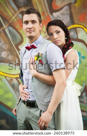 Portrait of just married happy couple. Wedding celebration. People in love. New family. Young man and beautiful woman in white wedding dress standing and embracing outdoors in green summer park