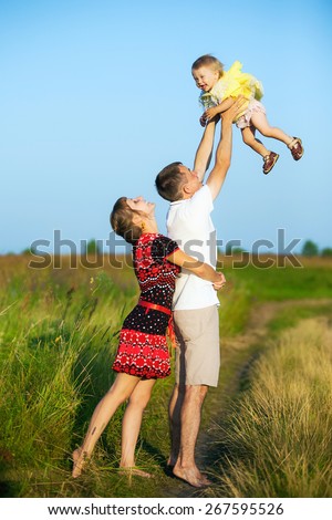 Happy family having fun outdoors in summer meadow. Father playing with child. Family concept. Picnic. Man holding little girl in hands. Laughing, smiling people