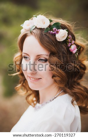 beautiful woman portrait.  flower wreath in hair of bride. smiley female face. close up of young girl outside.