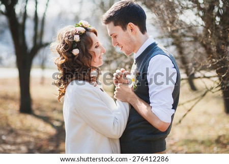 smiling Caucasian couple in wedding day. spring time. bride and groom holding hands together outdoors. happy bride and groom