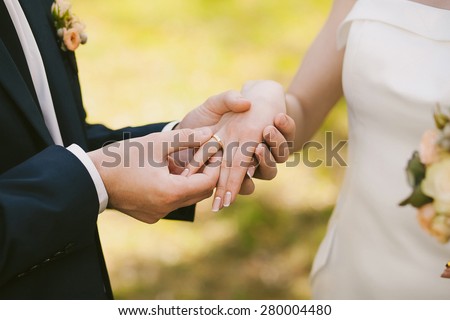 wedding rings and hands of bride and groom. young wedding couple at ceremony. matrimony. man and woman in love. two happy people celebrating becoming family