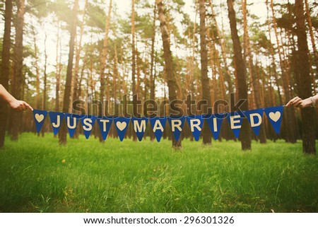 Anonymous Just Married Couple Holding Festive Inscription in Hands