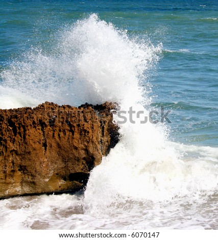 A wave breaking on a rocky cliff.