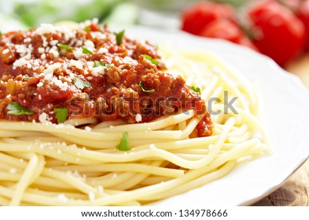 Spaghetti Bolognese on white plate, wooden table