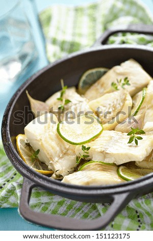 Baked fish fillet with lemon, lime, garlic and thyme
