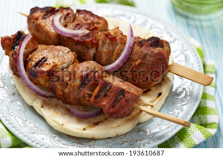 meat skewer with spice and onion on pita bread