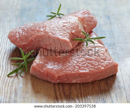 Raw veal meat steak on wooden table