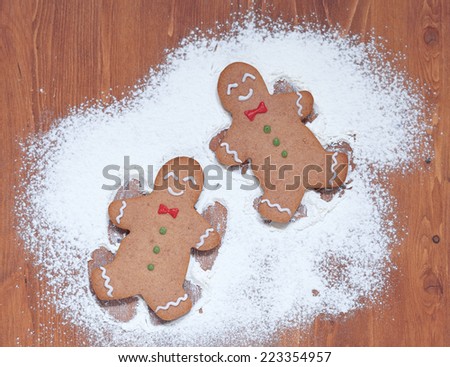 gingerbread man making a snow angel in white flour
