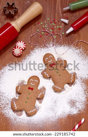 gingerbread man making a snow angel in white flour