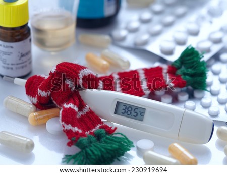 a fever thermometer and tablets. symbolic photo for flu and colds