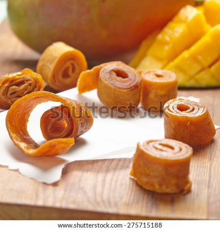 Mango fruit leather rolls on a cutting board