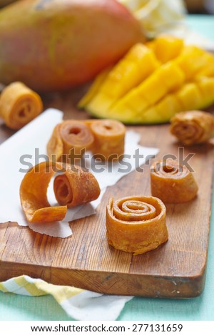 Mango fruit leather rolls on a cutting board