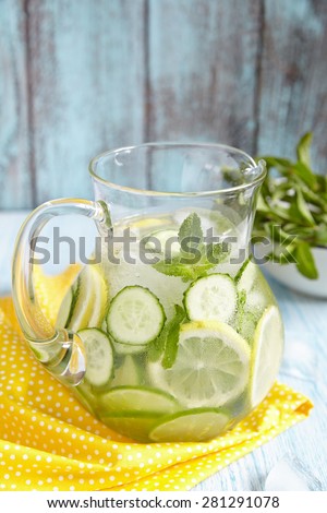 Fruit water with lemon, lime, cucumber and mint in glass pitcher