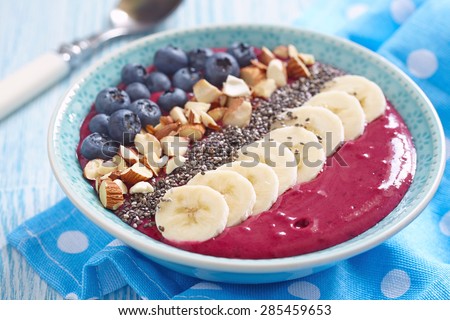Breakfast berry smoothie bowl topped with blueberry,almond, banana and chia seeds