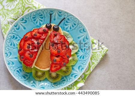 Funny ladybug pancakes with berries for kids breakfast