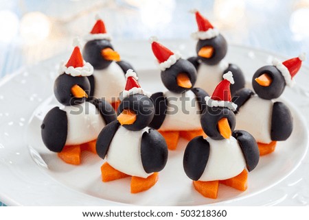 olive penguins snack with mozzarella, carrot and pepper santa hat