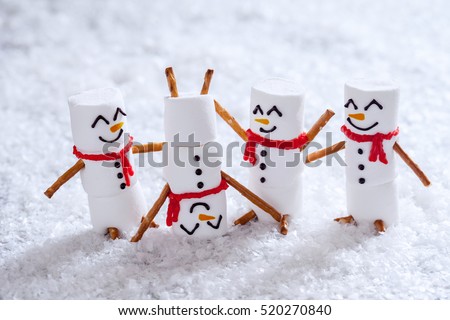 Happy funny marshmallow snowmans are having fun in snow