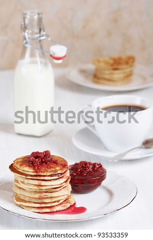 Tasty oatmeal pancakes with raspberry jam, coffee and milk