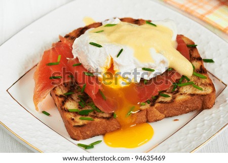 Egg benedict with hollandaise sauce and smoked salmon on toast for breakfast