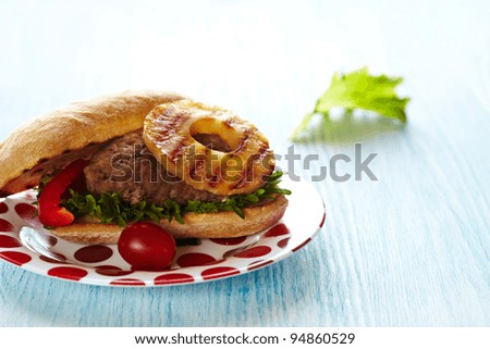 Fresh hamburger sandwich with lettuce, tomato and grilled pineapple