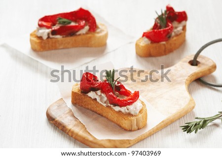 Fresh toast sandwiches with grilled bell pepper, cheese and rosemary on the cutting board
