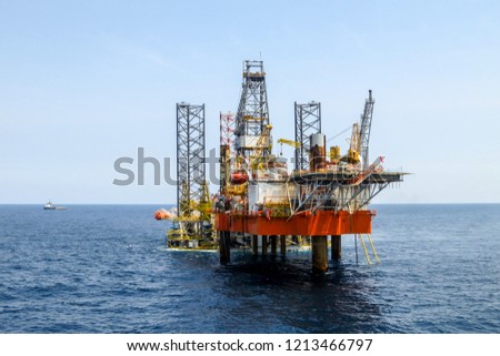 Drilling rig is installed side by side to production oil platform in offshore oil and gas field.