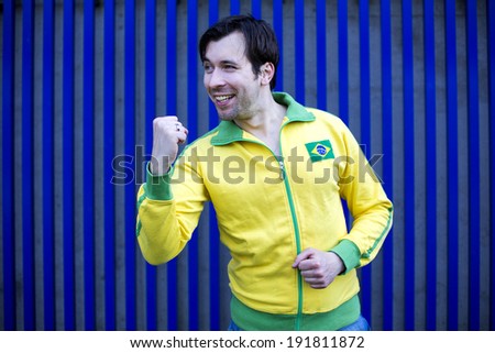man in yellow sports jacket makes a fist for victory