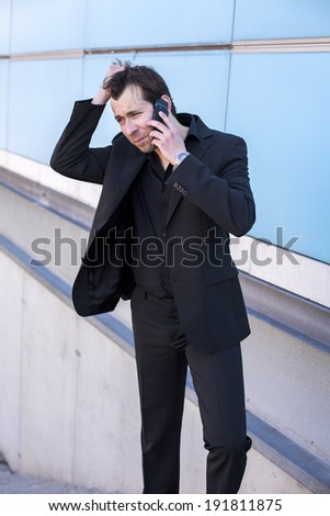 businessman outside on the phone and looking very concerned