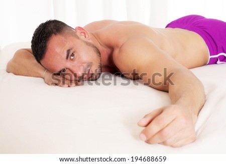 man with naked torso lying in bed