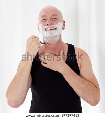 bald-headed man shaving and smiling