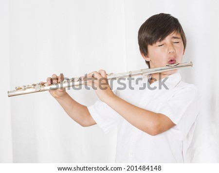 portrait of a boy playing the flute with his eyes closed