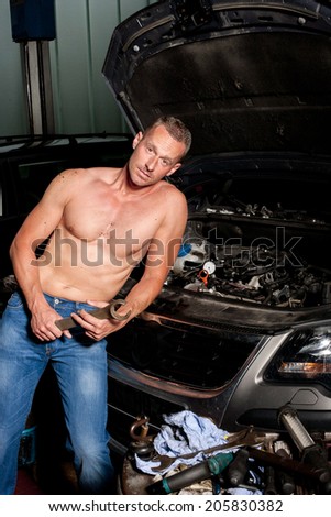 auto mechanic at service station with naked upper body