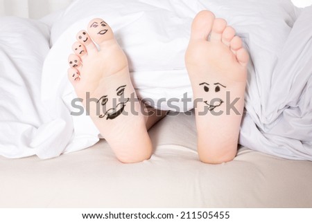 bare feet with smiley faces drawn on bottom