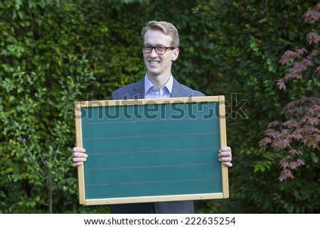 young man in a suit holding a panel