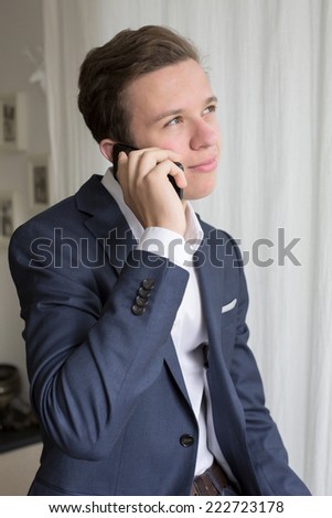 young man in a suit talking on the phone