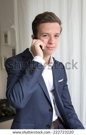 young man in a suit talking on the phone