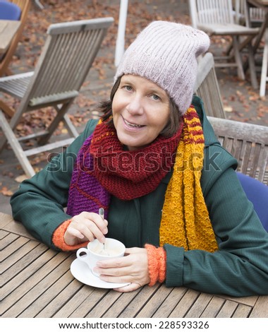 woman sitting outside in a cafe in autumn