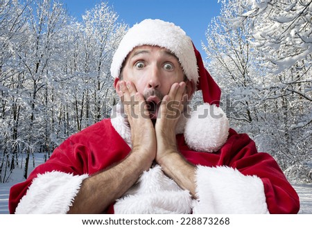 man dressed as Santa in the snow looking surprised and scared