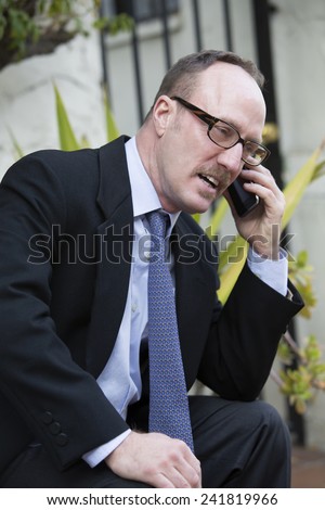 businessman sitting outside talking on the phone