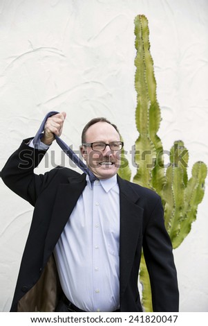businessman standing outside and pulling his tie