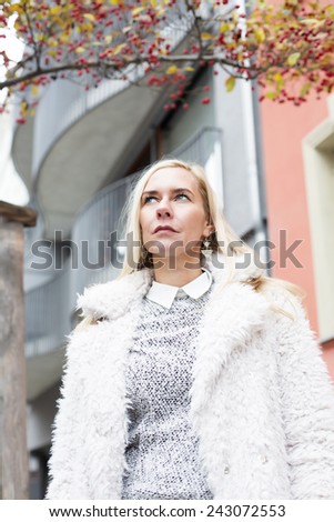 blond woman standing outside and looking sad