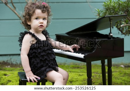 little girl playing on a toy piano