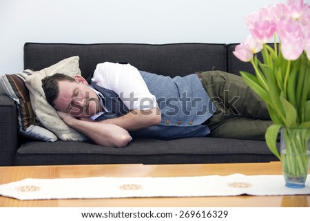 handsome businessman in his 50\'s sleeping on couch