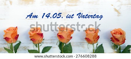 orange roses on wood with german text: Am 14.05. ist Vatertag (fathers day is on 14.05.)