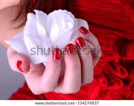 White rose in hand with red nail
