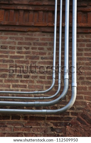 Fiber and power rigid conduits installed on the brick wall