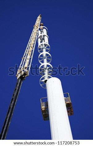 Assembilig cell tower with the crane - installation of the top part with stelath cell antennas.