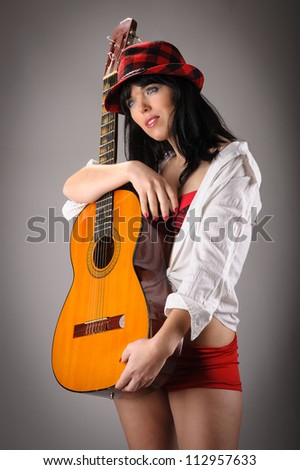 beautiful young woman like music star holding a classic guitar