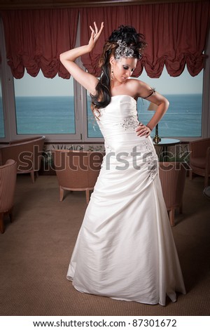 Bride at the hotel in white dress and professionally done hair and makeup.
